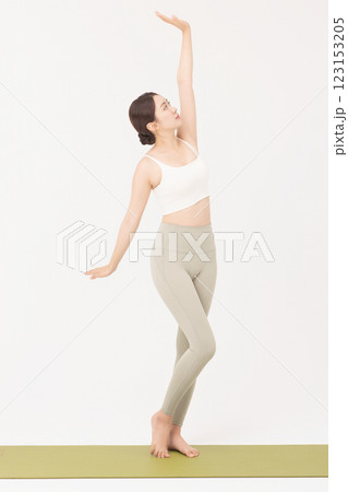 Portrait of a young woman wearing sportswear and stretching on a yoga mat Portrait of a young woman wearing sportswear and stretching on a yoga mat 123153205