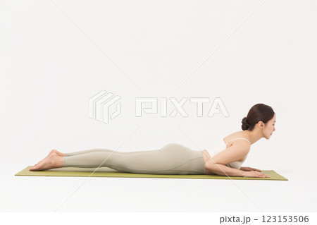 Portrait of a young woman wearing sportswear and doing yoga on a yoga mat Portrait of a young woman wearing sportswear and doing yoga on a yoga mat 123153506