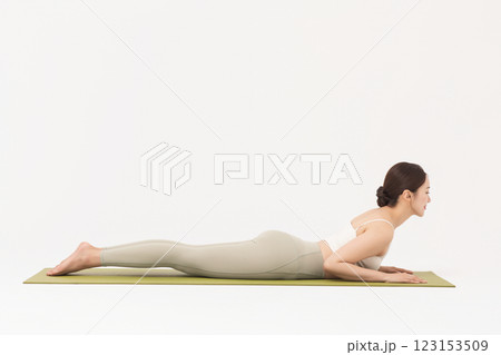 Portrait of a young woman wearing sportswear and doing yoga on a yoga mat Portrait of a young woman wearing sportswear and doing yoga on a yoga mat 123153509
