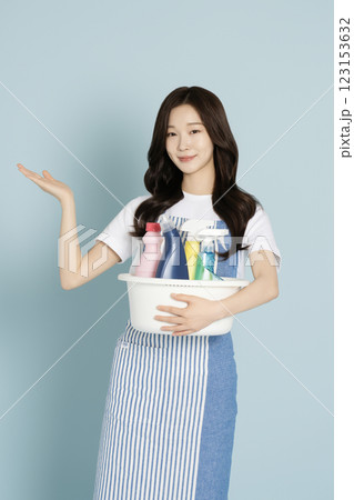 A woman in her 20s holding a basin containing cleaning tools for cleaning A woman in her 20s holding a basin containing cleaning tools for cleaning 123153632