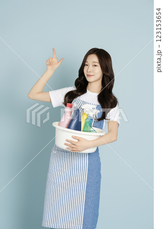 A woman in her 20s holding a basin containing cleaning tools for cleaning A woman in her 20s holding a basin containing cleaning tools for cleaning 123153654