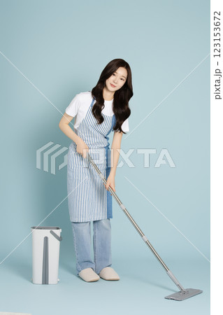 A woman in her 20s mopping the floor with a gunny mop A woman in her 20s mopping the floor with a gunny mop 123153672