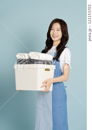 A woman in her 20s carrying living boxes and towels 123153703