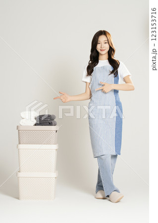 A woman in her 20s standing next to a living box and towel 123153716