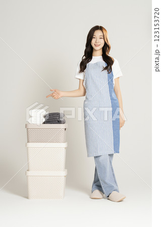 A woman in her 20s standing next to a living box and towel 123153720