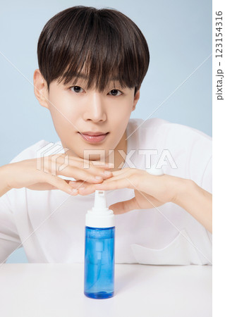 A young man demonstrating basic men's cosmetics A young man demonstrating basic men's cosmetics 123154316