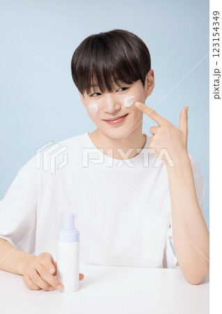 A young man demonstrating basic men's cosmetics A young man demonstrating basic men's cosmetics 123154349