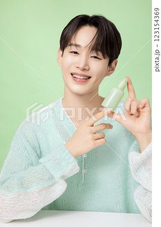 A man in his 20s posing with green essence A man in his 20s posing with green essence 123154369