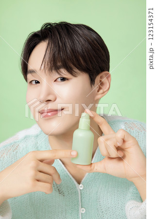 A man in his 20s posing with green essence A man in his 20s posing with green essence 123154371