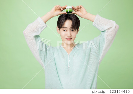 A man in his 20s posing with green essence A man in his 20s posing with green essence 123154410