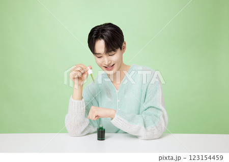 A man in his 20s posing with green essence A man in his 20s posing with green essence 123154459