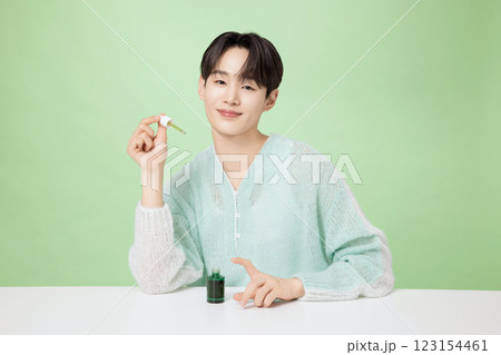 A man in his 20s posing with green essence A man in his 20s posing with green essence 123154461