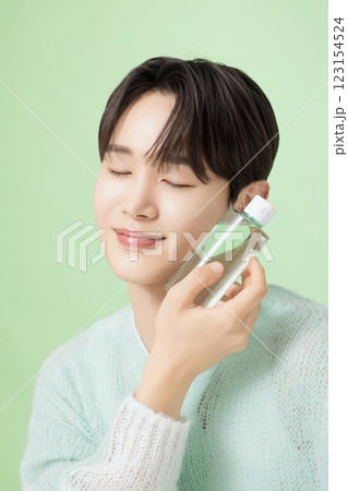 A man in his 20s posing with green essence 123154524