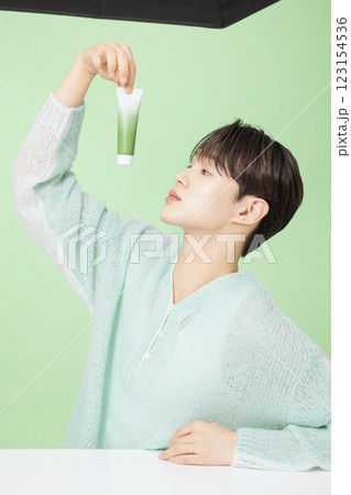 A man in his 20s posing with green essence A man in his 20s posing with green essence 123154536