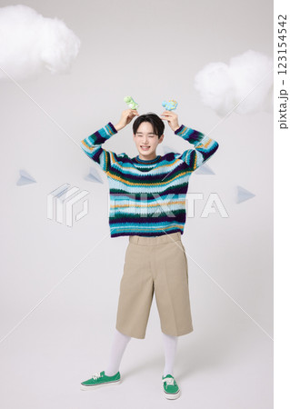 Portrait of man holding dinosaur candy in clouds 123154542