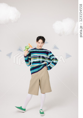 Cropped view of man standing in clouds holding toy bubble gun 123154558