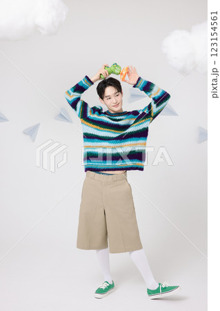 Cropped view of man standing in clouds holding toy bubble gun 123154561