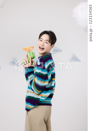 Cropped view of man standing in clouds holding toy bubble gun Cropped view of man standing in clouds holding toy bubble gun 123154565