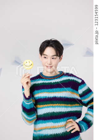 Portrait of a man standing in the clouds holding candy Portrait of a man standing in the clouds holding candy 123154599