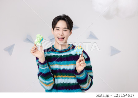 Portrait of a man standing in the clouds holding candy 123154617