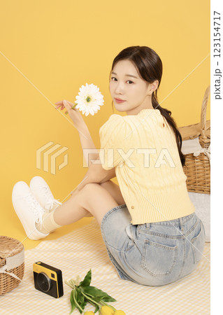 A woman in her 20s spreading out a mat and enjoying a picnic A woman in her 20s spreading out a mat and enjoying a picnic 123154717