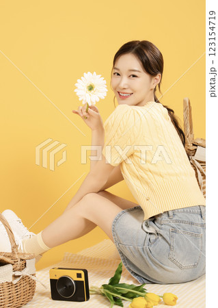 A woman in her 20s spreading out a mat and enjoying a picnic 123154719