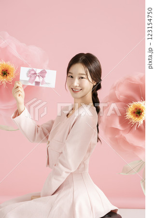 An innocent woman in her 20s wearing a pink two-piece with a large flower in the background. An innocent woman in her 20s wearing a pink two-piece with a large flower in the background. 123154750