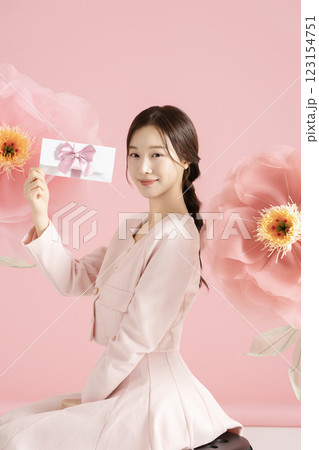 An innocent woman in her 20s wearing a pink two-piece with a large flower in the background. An innocent woman in her 20s wearing a pink two-piece with a large flower in the background. 123154751