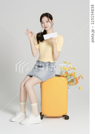 A woman in her 20s traveling with a suitcase 123154838