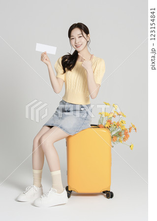 A woman in her 20s traveling with a suitcase 123154841