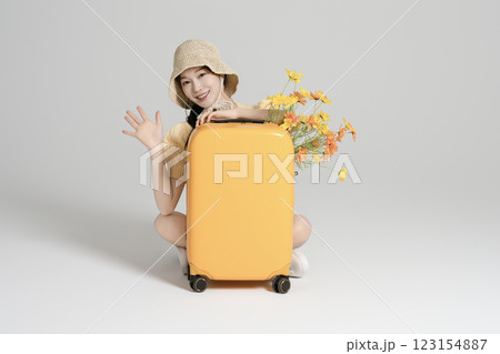 A woman in her 20s traveling with a suitcase 123154887