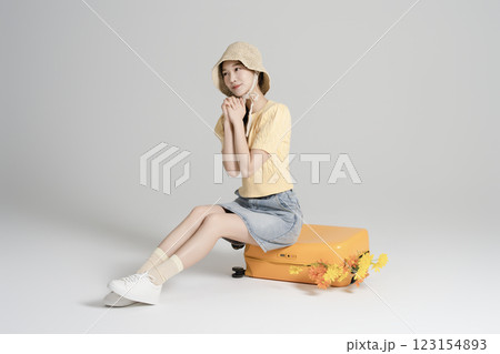 A woman in her 20s traveling with a suitcase 123154893