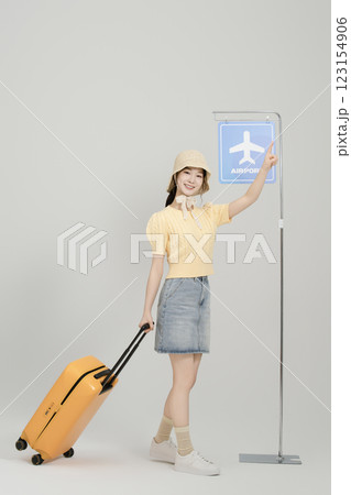 A woman in her 20s waiting for the airport bus with a suitcase 123154906