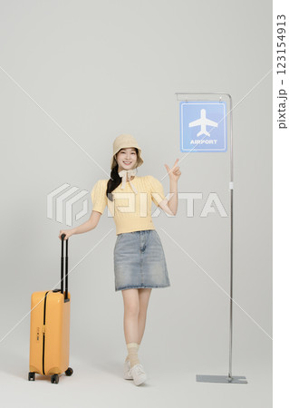 A woman in her 20s waiting for the airport bus with a suitcase 123154913