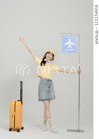 A woman in her 20s waiting for the airport bus with a suitcase 123154916