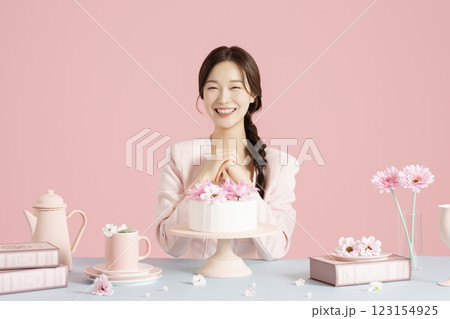 A woman in her 20s smiling brightly while sitting in front of a cake 123154925