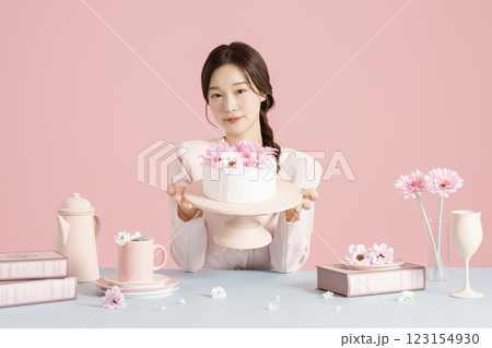 A woman in her 20s holding a cake and showing it off 123154930