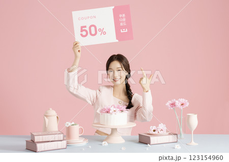 A woman in her 20s sitting in front of a cake and scooping up flowers with a fork. A woman in her 20s sitting in front of a cake and scooping up flowers with a fork. 123154960