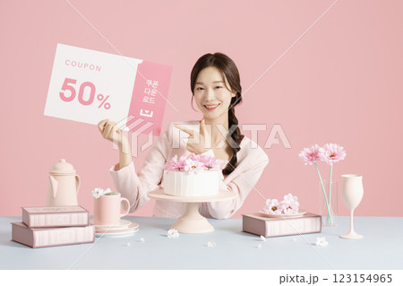 A woman in her 20s sitting in front of a cake and holding a coupon A woman in her 20s sitting in front of a cake and holding a coupon 123154965