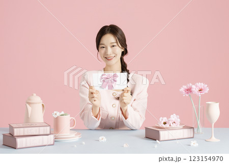 A woman in her 20s holding a beautifully packaged gift certificate 123154970
