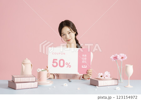 A woman in her 20s holding a coupon A woman in her 20s holding a coupon 123154972