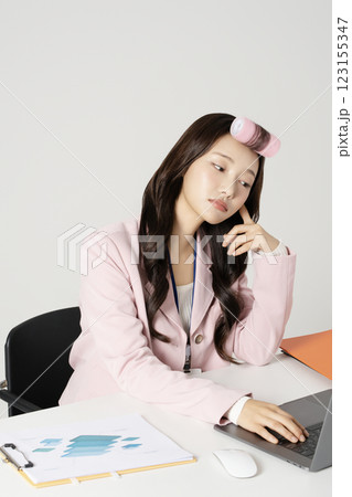 MZ employee using a laptop while wearing a hair roller MZ employee using a laptop while wearing a hair roller 123155347