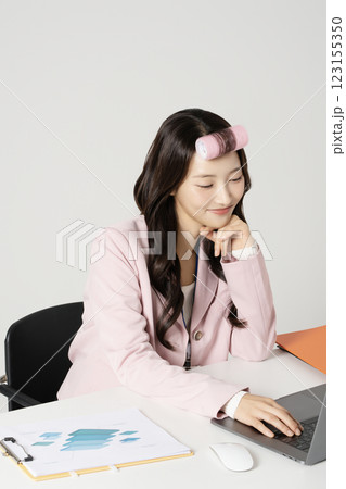 MZ employee using a laptop while wearing a hair roller MZ employee using a laptop while wearing a hair roller 123155350