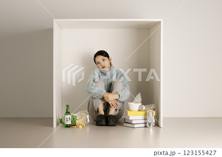 A student stacking books in a box and drinking soju A student stacking books in a box and drinking soju 123155427