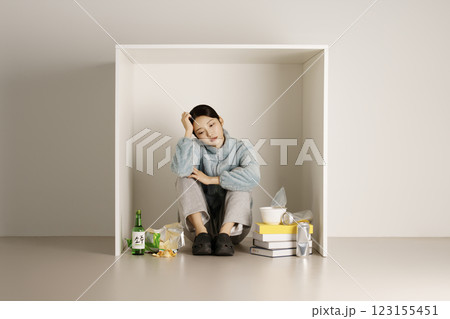A student stacking books in a box and drinking soju A student stacking books in a box and drinking soju 123155451