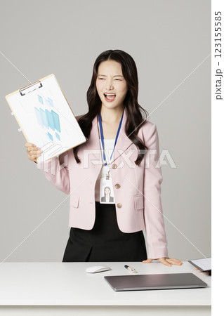 MZ employee in his 20s standing in front of his office desk holding documents 123155585