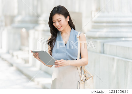 ビジネス街でタブレットを見ているビジネスウーマン 123155625