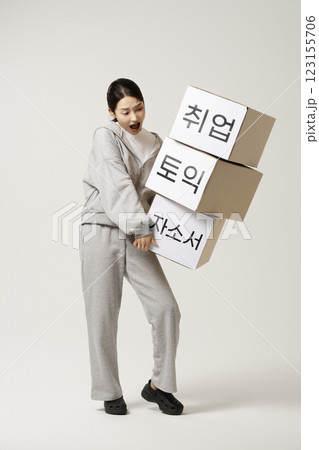 A job seeker in his 20s carrying heavy boxes including personal statements, employment, starting a business, and TOEIC. 123155706