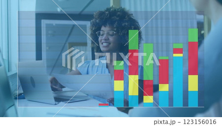 Businesswoman reviewing documents, bar chart image over office background 123156016