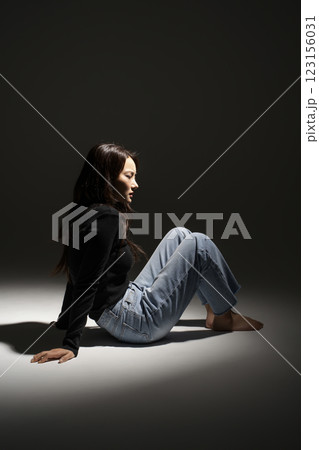 Portrait of a woman sitting in a lighted area 123156031